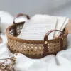 Aufbewahrungskorb aus Rattan mit Lederhenkeln Aufbewahrungskorb aus Rattan mit Lederhenkeln