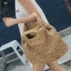 Strandtasche aus geflochtenem Stroh mit Holzgriffen Strandtasche aus geflochtenem Stroh mit Holzgriffen