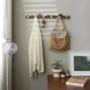 Wandgarderobe aus Holz mit goldenen Haken Wandgarderobe aus Holz mit goldenen Haken